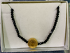 Cadena acero dorado san Benito piedritas negras